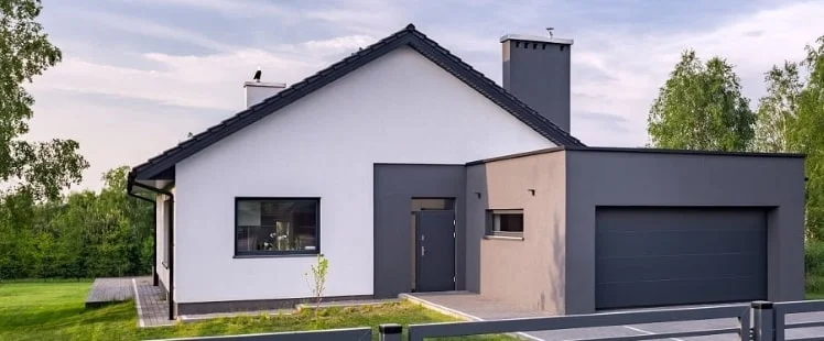 Satteldach mit Garten und angebauter Garage mit dunkelbrauner Außenfassade.
