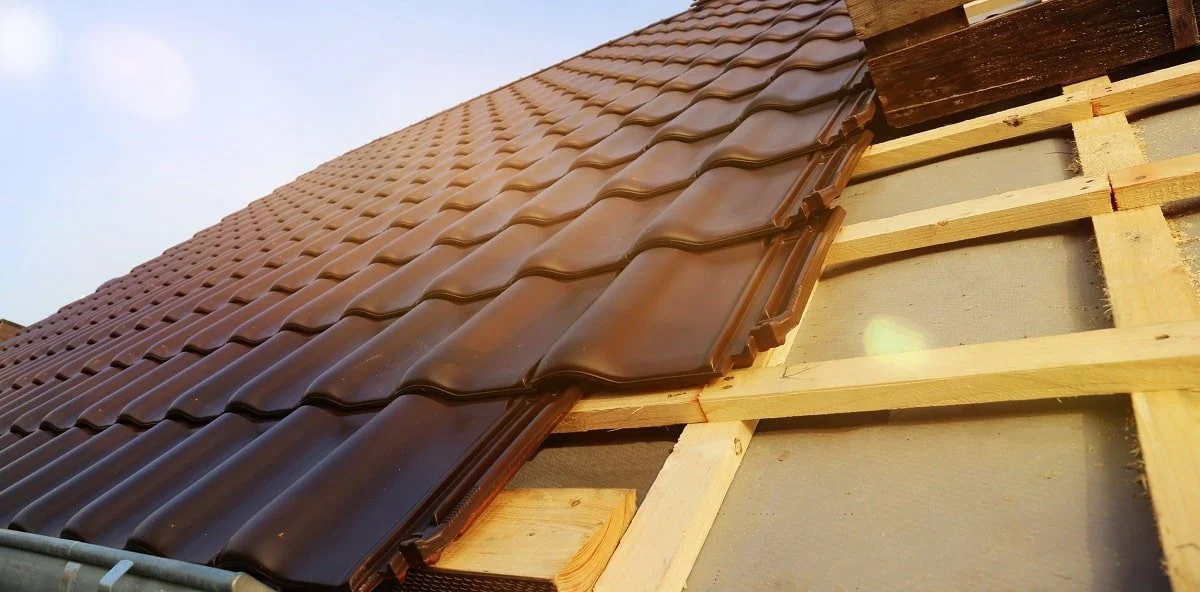 Satteldach, dass mit braunen Dachziegeln besetzt wird.