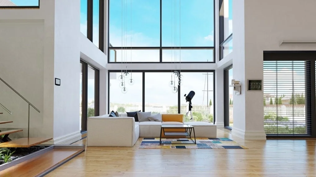 Wohnzimmerbereich mit Sofa und einem Wohnzimmertisch, eine Glasfront erhellt den Raum