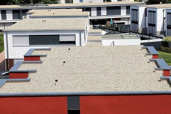 Vogelperspektive auf Flachdachhäuser. Die Dachkonstruktion besteht aus Kieselsteinen.