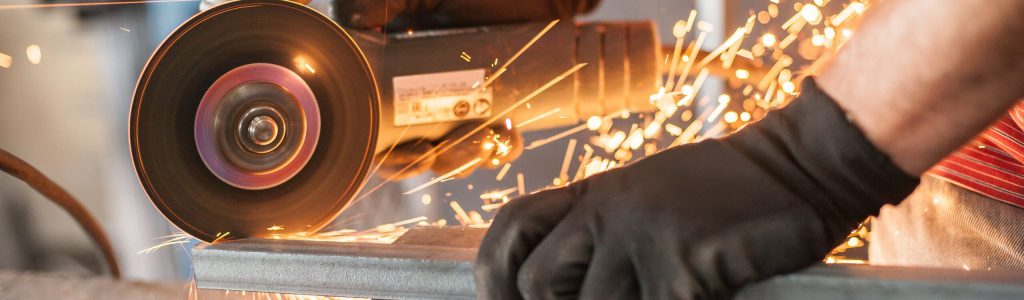 Electric wheel grinding on steel structure in factory Winkelschleifer beim schleifen von Metall, wodurch Funken entstehen